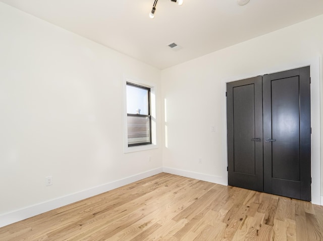 unfurnished bedroom featuring light wood-type flooring and a closet