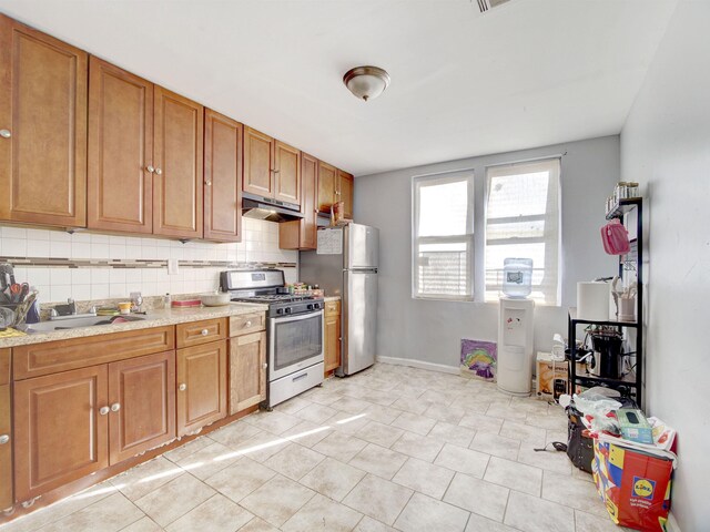 kitchen featuring light tile patterned flooring, backsplash, and appliances with stainless steel finishes