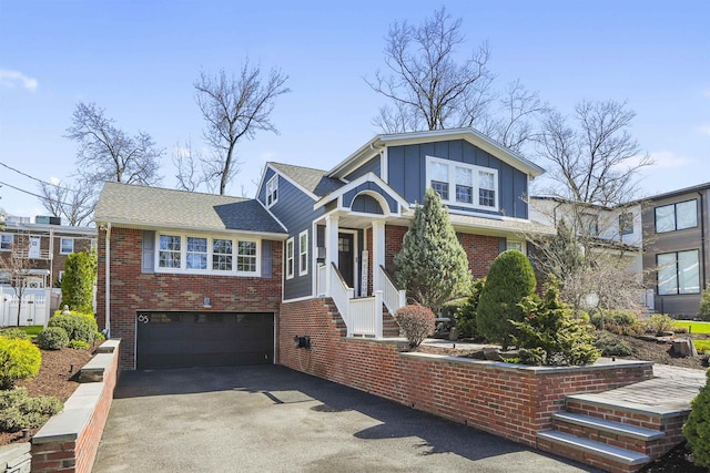 65 Dillingham Pl, Englewood Cliffs, NJ 07632 - view of front of property featuring board and batten siding, brick siding, a garage, and aphalt driveway