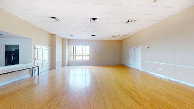 empty room with baseboards, light wood-type flooring, and visible vents