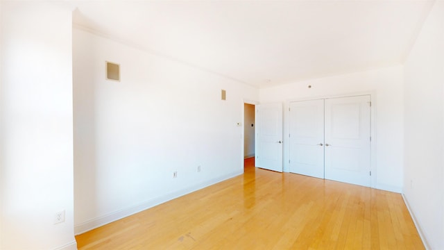 unfurnished bedroom featuring a closet, baseboards, and light wood-style floors
