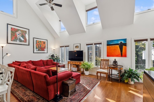 living room with wood-type flooring, plenty of natural light, and high vaulted ceiling