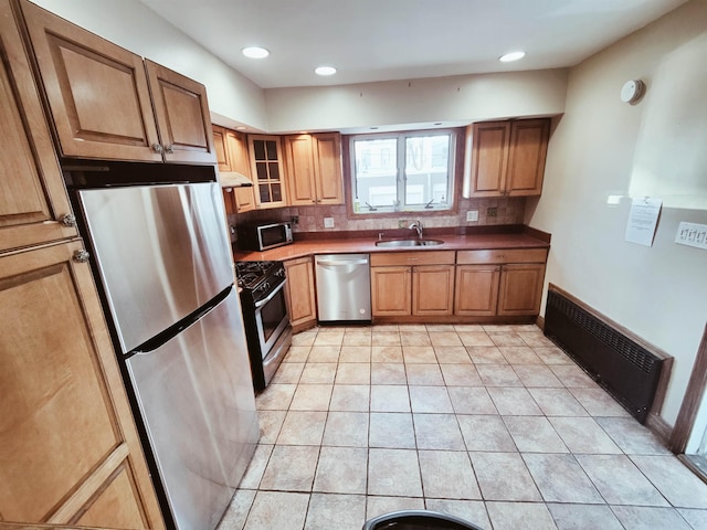 kitchen with sink, decorative backsplash, light tile patterned floors, and appliances with stainless steel finishes