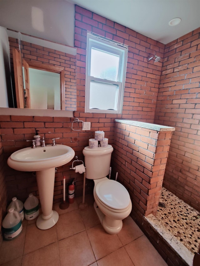 bathroom featuring tile patterned flooring, a tile shower, and toilet