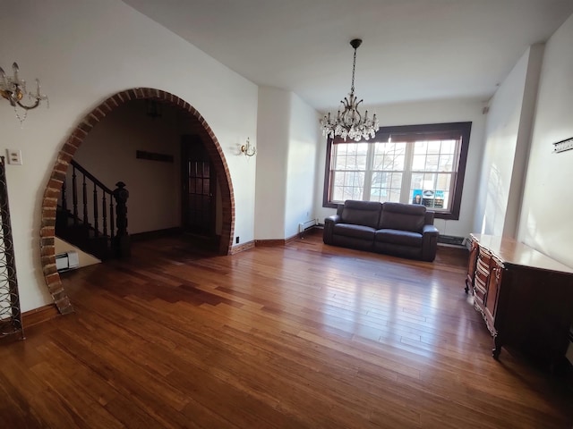 living room with dark hardwood / wood-style floors, a chandelier, and a baseboard heating unit