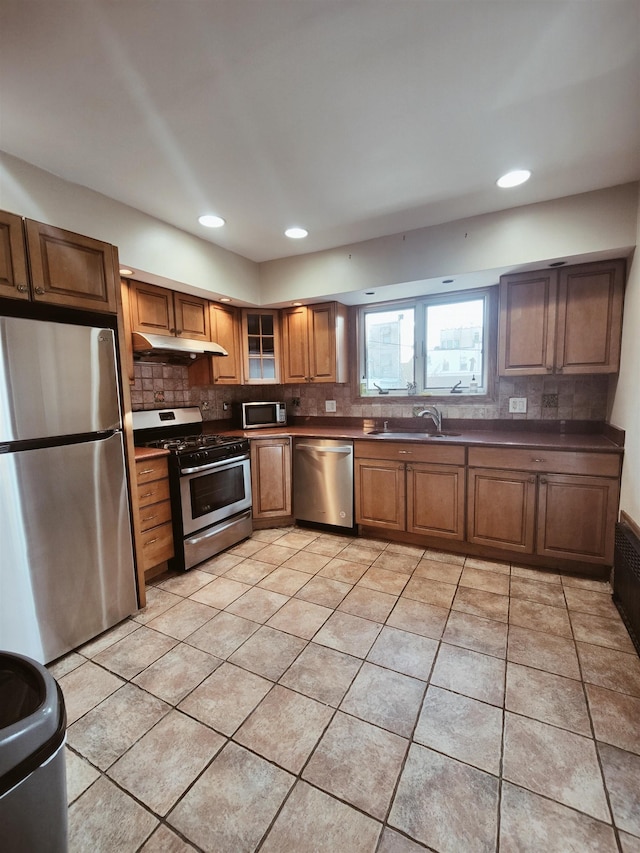 kitchen featuring light tile patterned flooring, appliances with stainless steel finishes, sink, and backsplash