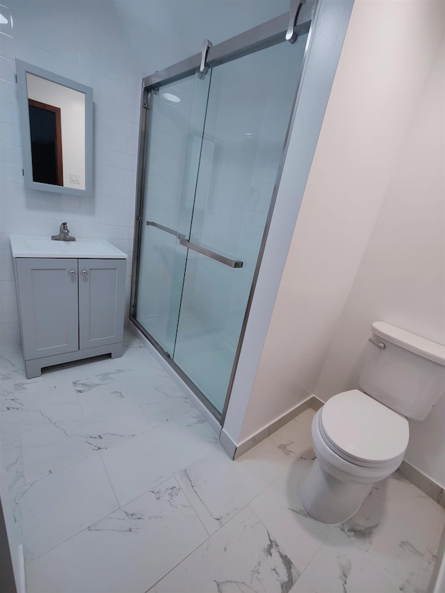 bathroom featuring vanity, a shower with shower door, and toilet