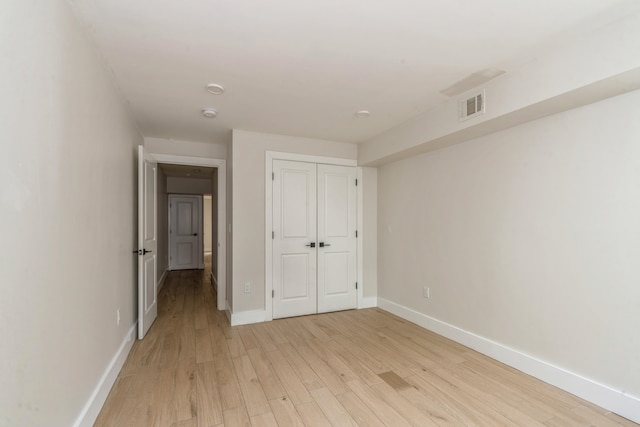 unfurnished bedroom with light hardwood / wood-style flooring and a closet