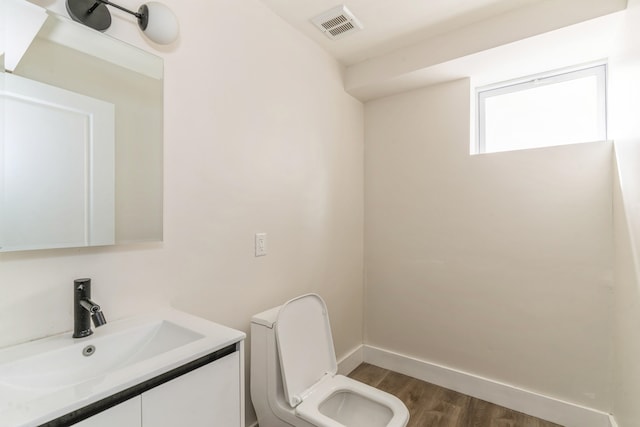 bathroom with hardwood / wood-style floors, vanity, and toilet