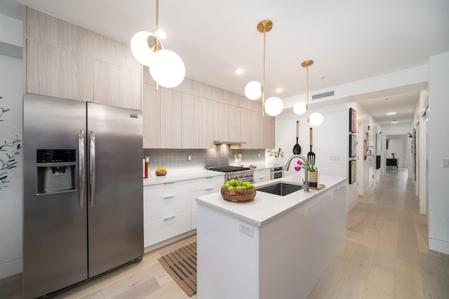 415 Monmouth St Apt. Three, Apt Three, Jersey City, NJ 07302 - kitchen with stainless steel appliances, modern cabinets, tasteful backsplash, a kitchen island with sink, and light wood-style flooring