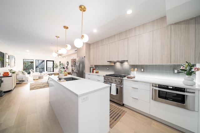 415 Monmouth St Apt. Three, Apt Three, Jersey City, NJ 07302 - kitchen featuring modern cabinets, stainless steel appliances, a chandelier, open floor plan, and decorative backsplash