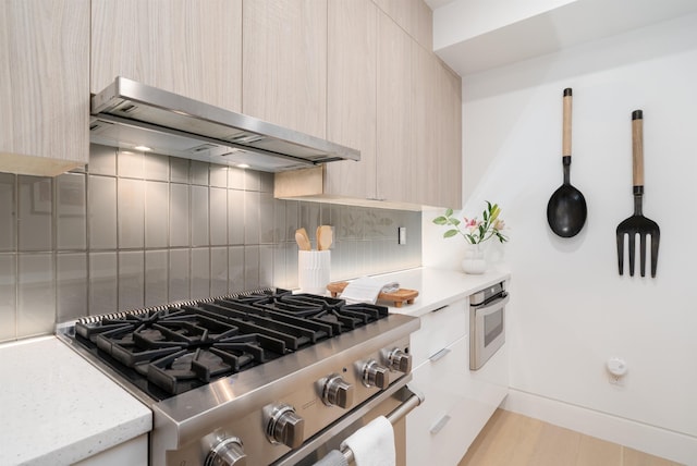415 Monmouth St Apt. Three, Apt Three, Jersey City, NJ 07302 - kitchen with stainless steel appliances, modern cabinets, wall chimney exhaust hood, light brown cabinets, and backsplash