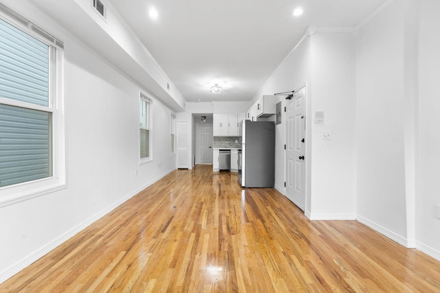 unfurnished living room with crown molding and light hardwood / wood-style flooring