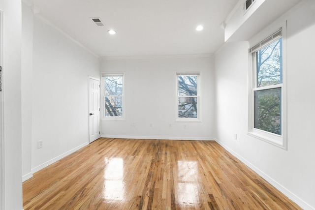 spare room featuring ornamental molding and light wood-type flooring