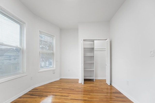 unfurnished bedroom with a closet and light hardwood / wood-style floors