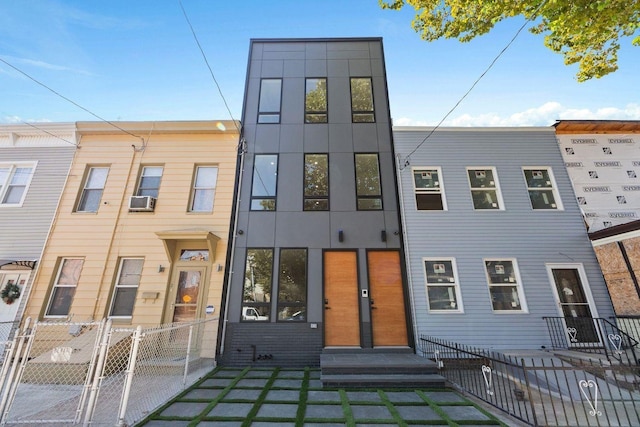 view of property with a fenced front yard, entry steps, and cooling unit