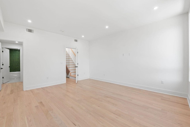 spare room featuring recessed lighting, visible vents, stairway, light wood-type flooring, and baseboards