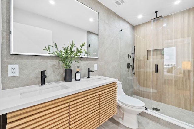 bathroom with a stall shower, visible vents, a sink, and tile walls