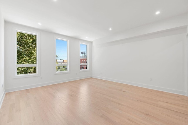 spare room featuring light wood-style flooring, baseboards, and recessed lighting