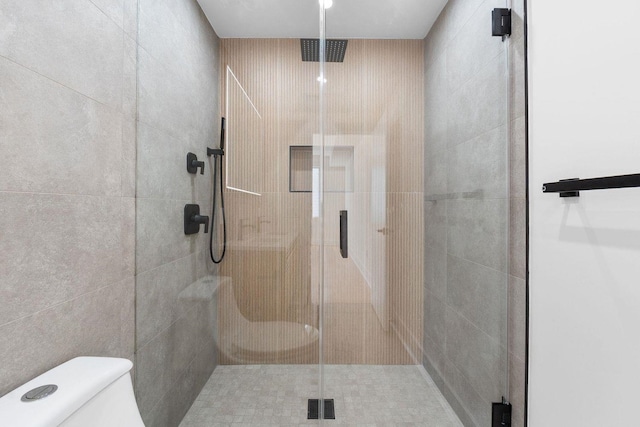 bathroom featuring toilet and a stall shower