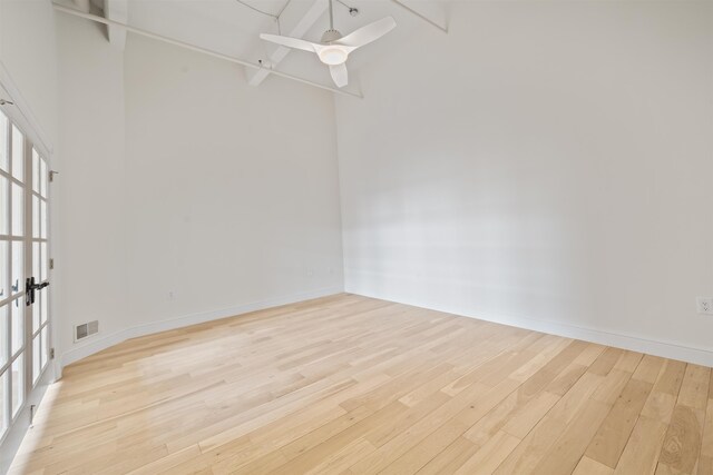 300 Communipaw Ave Unit 122, Jersey City, NJ 07304 - unfurnished room featuring light wood-style flooring, a ceiling fan, and a high ceiling