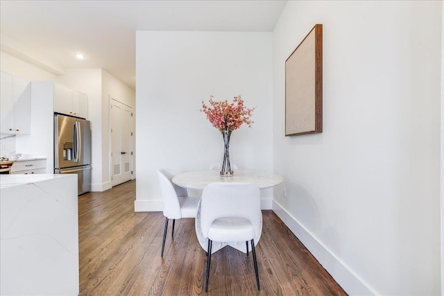 dining space featuring recessed lighting, wood finished floors, and baseboards