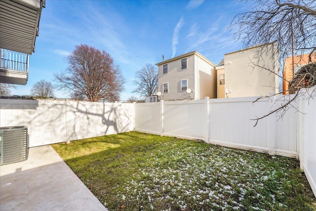 view of yard with central air condition unit and a fenced backyard