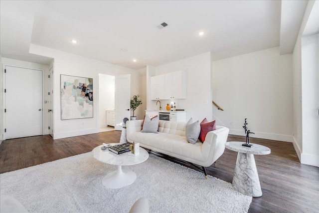 living area with dark wood-style floors, visible vents, recessed lighting, and stairway