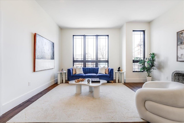 living area featuring dark wood-type flooring and baseboards