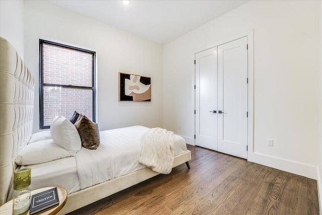 bedroom with a closet, baseboards, and wood finished floors