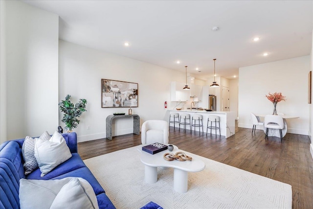 living area with dark wood-style floors, recessed lighting, and baseboards
