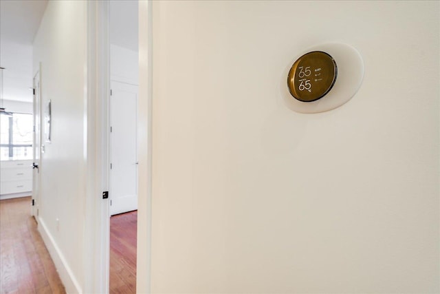 corridor featuring baseboards and light wood-style floors