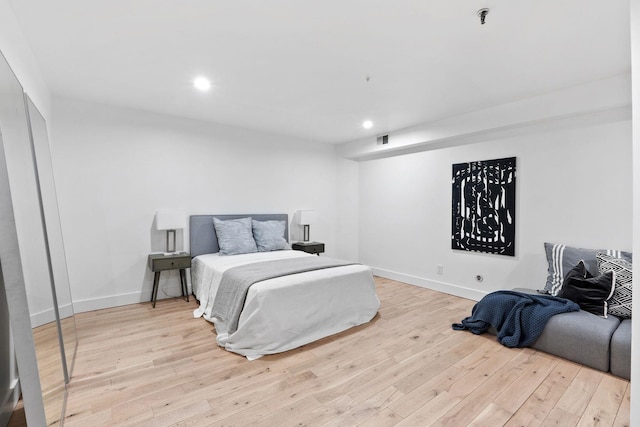 bedroom featuring light wood-type flooring, baseboards, visible vents, and recessed lighting