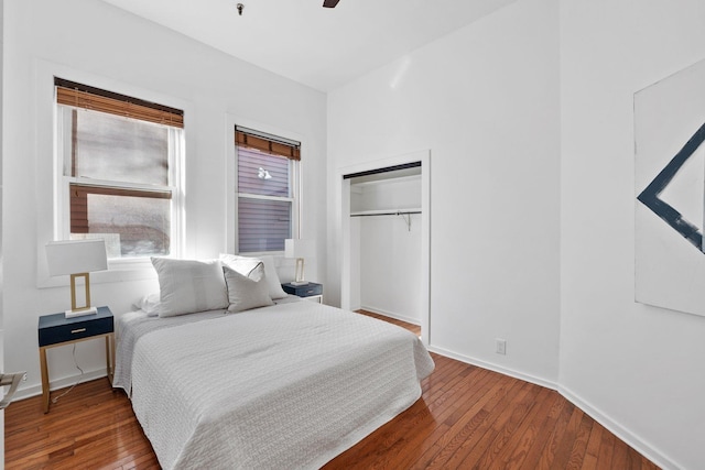 bedroom with a closet, baseboards, a ceiling fan, and hardwood / wood-style floors