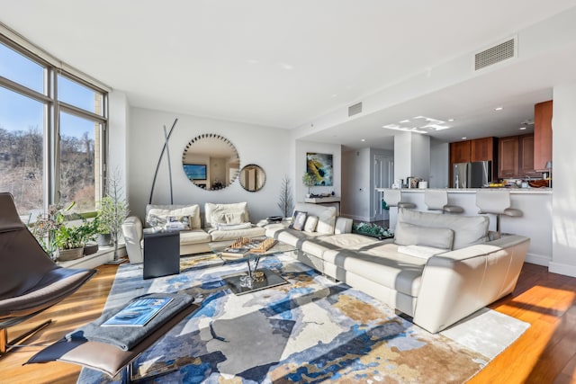 living room featuring light hardwood / wood-style floors and a wall of windows