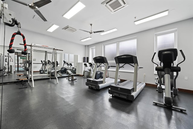 gym with visible vents, ceiling fan, and baseboards