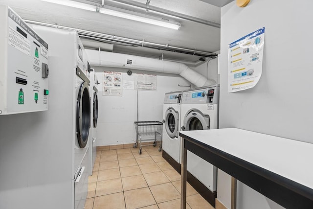 shared laundry area with light tile patterned floors and washer and clothes dryer