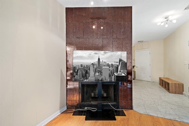 living area featuring visible vents, baseboards, and wood finished floors