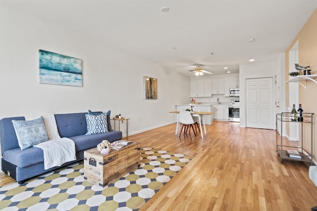 living area with baseboards, recessed lighting, light wood-style flooring, and ceiling fan