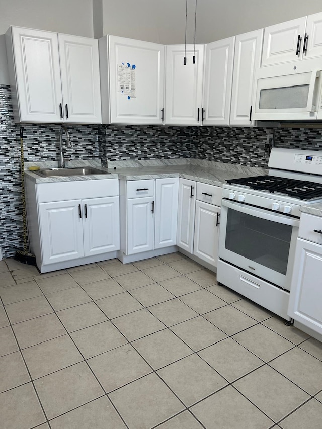 kitchen with tasteful backsplash, white appliances, sink, light tile patterned floors, and white cabinetry