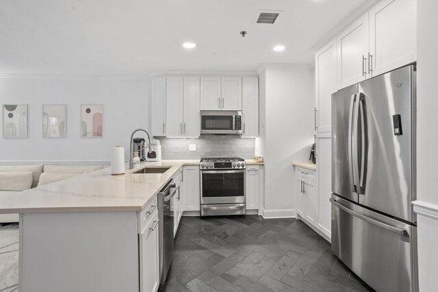 501 9th St Unit 407, Hoboken, NJ 07030 - kitchen featuring stainless steel appliances, a peninsula, recessed lighting, white cabinets, and backsplash