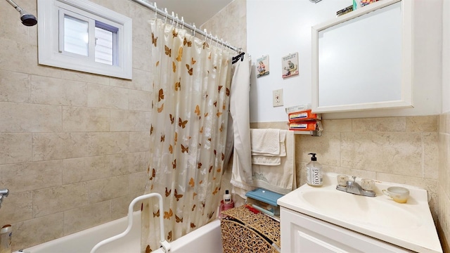bathroom featuring tasteful backsplash, vanity, shower / tub combo with curtain, and tile walls