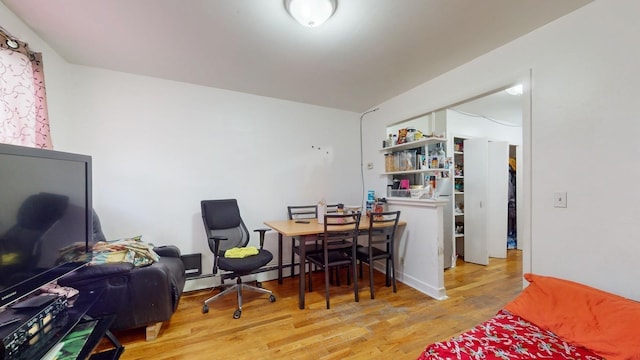 bedroom with a baseboard radiator and wood finished floors