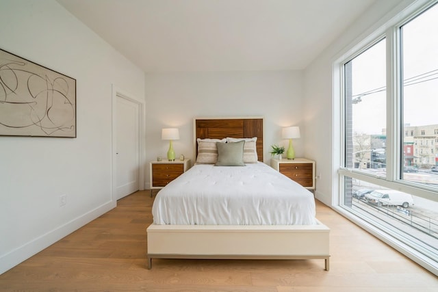 bedroom featuring light wood-style floors and baseboards