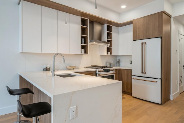 kitchen featuring a sink, wall chimney exhaust hood, open shelves, high end appliances, and modern cabinets