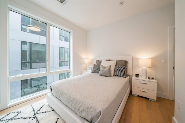 bedroom featuring light wood-style floors, baseboards, and visible vents