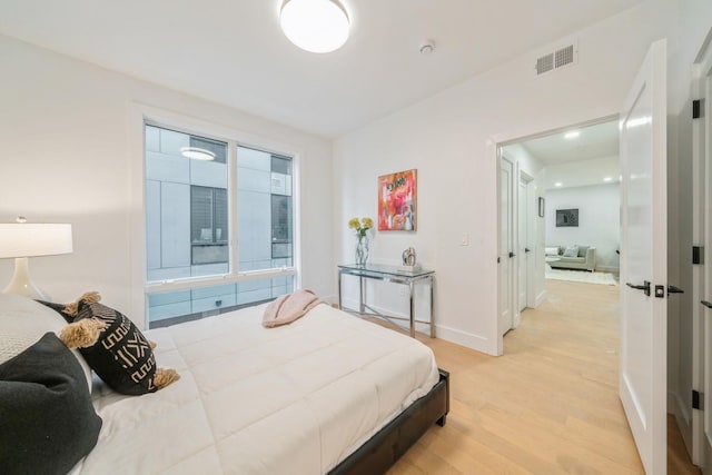 bedroom featuring light wood-style flooring, baseboards, and visible vents