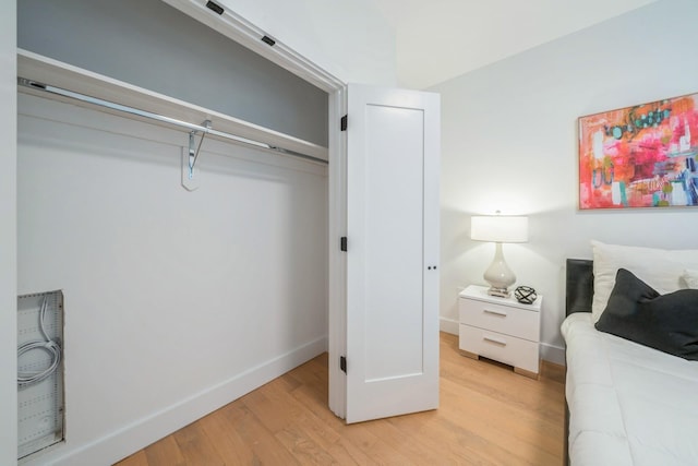 bedroom featuring light wood finished floors and baseboards