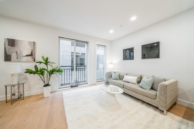 living area with recessed lighting, light wood-style flooring, and baseboards