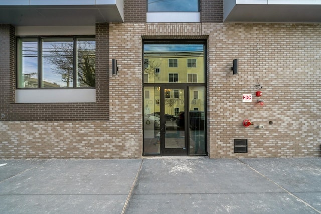 entrance to property featuring crawl space and brick siding